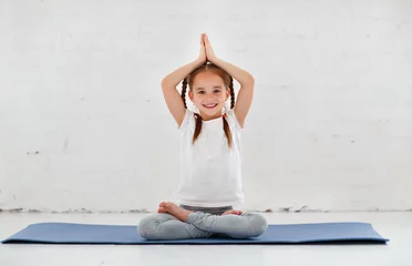 Foto op Canvas kind meisje doet yoga en gymnastiek in de sportschool © JenkoAtaman