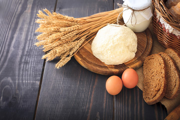 Farm products: eggs, milk, bread on a wooden table.