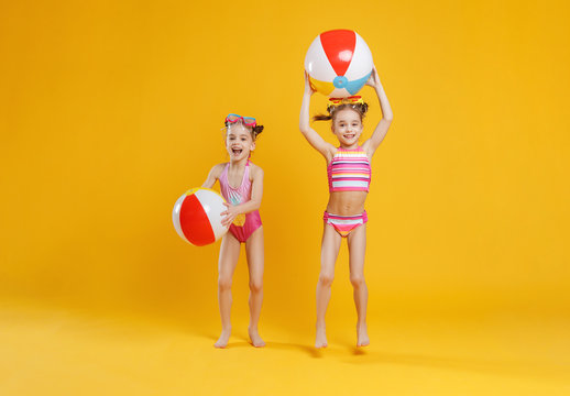 funny funny happy children in bathing suits  jumping  on colored background