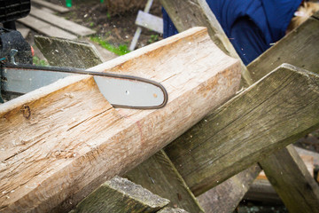Cut logs for firewood with a chain saw