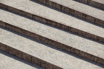 Abstract diagonal stairs, old worn granite staircase on a city square, wide stone stairway perspective often seen near monuments and landmarks.