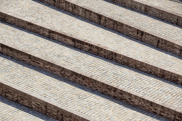 Abstract diagonal stairs, old worn granite staircase on a city square, wide stone stairway perspective often seen near monuments and landmarks.