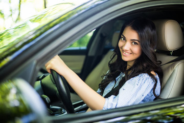 Obraz na płótnie Canvas Pretty young woman driving her new car.