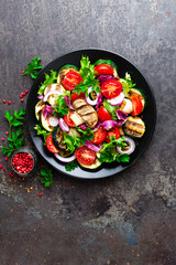 Salad with fresh and grilled vegetables and mushrooms. Vegetable salad with grilled champignons. Vegetable salad on plate. Healthy vegetarian food