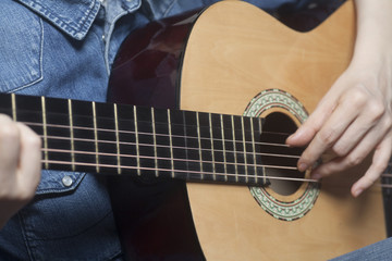 Fototapeta premium Young womans hands playing a acoustic classic guitar