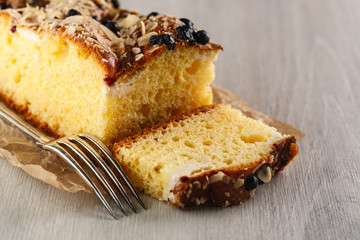 cake with almonds and blueberries on wooden table. Closeup