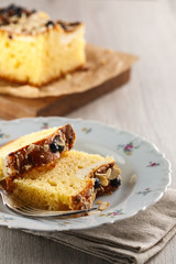 sliced cake with almonds and blueberries on a white ceramic plate