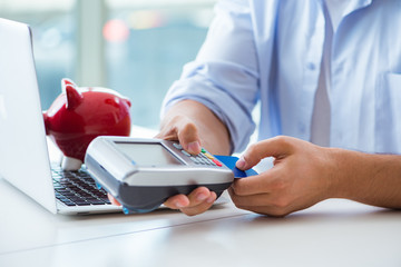 Man processing credit card transaction with POS terminal