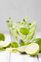 Summer refreshing cocktail caipirinha with lime and mint on white wooden vintage background.
