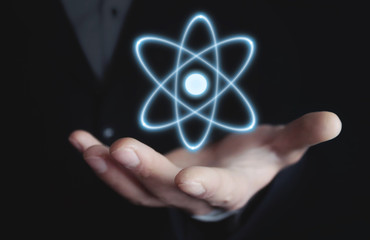 Caucasian businessman holding atom. Power and innovation concept