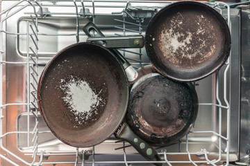 Dirty pans lie in the dishwasher for washing