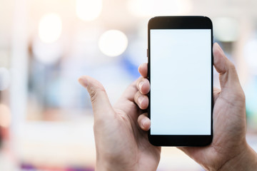 business communication ideas concept with hand hold white blank screen smartphone with blur bokeh mall background