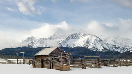 Beautiful Western scene with wood corral and winter Sawtooth Mountains backdrop