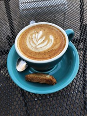 Delicious cappuccino coffee in a blue mug 