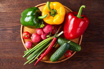 Composition of vegetables on flat plate on wooden table, close-up, selective focus