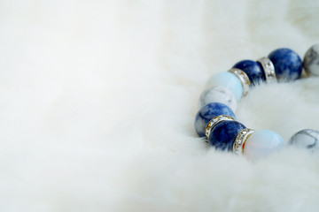 Blue and white color tone lucky fortune stone bracelet include which Lapis lazuli, Sodalite, Howlite and Moonstone on white wool background. Amulet accessories for good lucky fortune and happy life