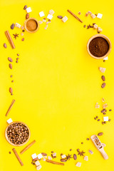 Fototapeta premium Ingredients for bakery and desserts. Cinnamon, cocoa, coffee, sugar, spices on yellow background top view space for text