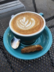 Delicious cappuccino coffee in a blue mug 