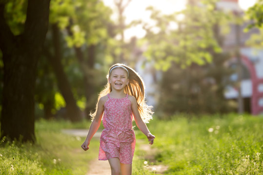 Little girl is running in the summer park
