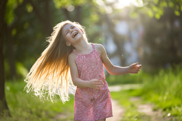 Little girl is shaking hair outdoor