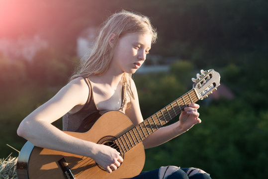 Woman playing guitar in nature relax time on holiday