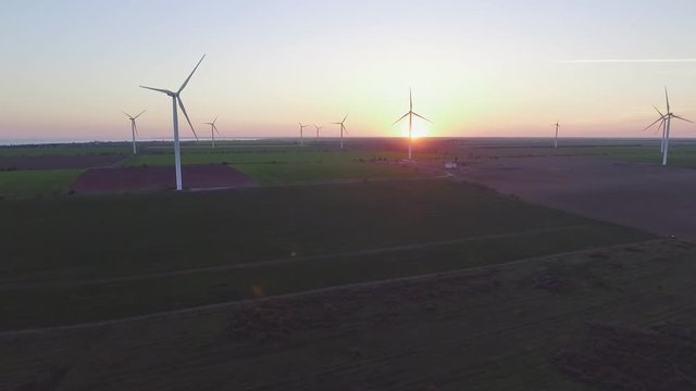 Wind turbine power generators silhouettes at sea coastline at sunset. Alternative renewable energy production in Ukraine. Aerial view