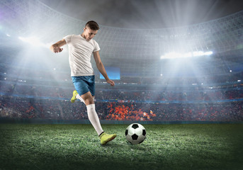 Soccer player on a football field in dynamic action at summer day