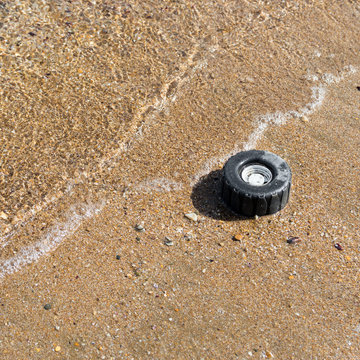 Plastic wheel from a toy in the sea sand on the shore