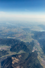 View from the airplane to the sky above the Alps mountains. Blue sky with clouds. Background.