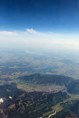 Fototapeta na wymiar View from the airplane to the sky above the Alps mountains. Blue sky with clouds. Background.