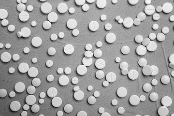 White pills on grey background, flat lay