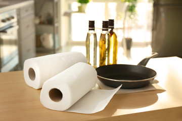 Rolls of paper towels and frying pan on kitchen table