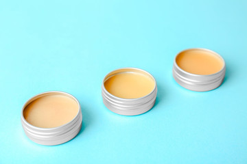 Lip balms on color background, closeup