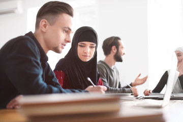 Muslim students with their classmates in library