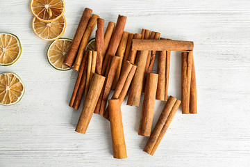Aromatic cinnamon sticks and lime slices on wooden background
