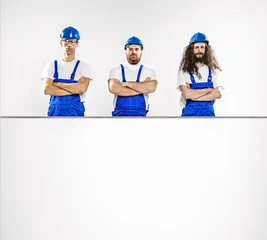 Fototapete Rund Drei talentierte Handwerker mit leerem Brett © konradbak