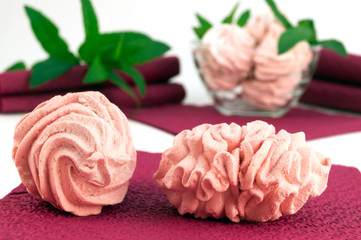 Two homemade cakes on a paper napkin on a background of green mint.