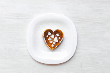 Freshly baked curd on the plate with powdered sugar on white wooden table background.