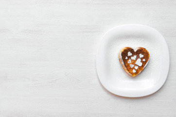 Freshly baked curd on the plate with powdered sugar on white wooden table background.
