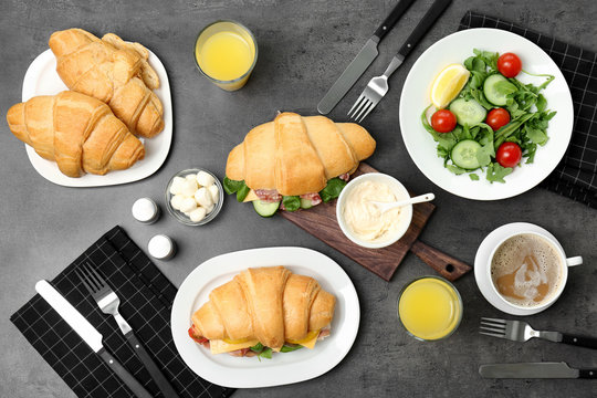 Tasty breakfast with fresh croissants on table, top view