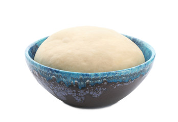 Bowl with raw dough on white background