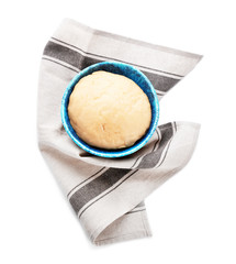 Bowl with raw dough on white background, top view