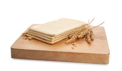Wooden board with fresh dough on white background. Puff pastry