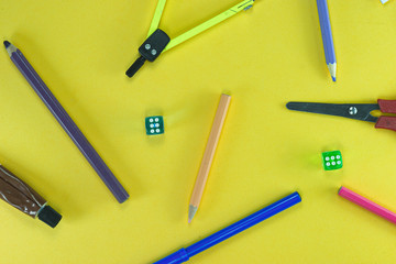 A group of school objects on yellow background. And dices.