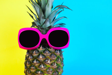 Fashion Pineapple. Summer Color. Tropical Fruit with Sunglasses. Minimalist style. Creative Art concept. Pineapple on pink, yellow and blue pastel colors.