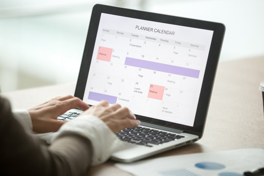 Businesswoman planning day using digital planner or calendar software application on laptop screen, employee making event schedule with personal organizer, time management concept, close up view