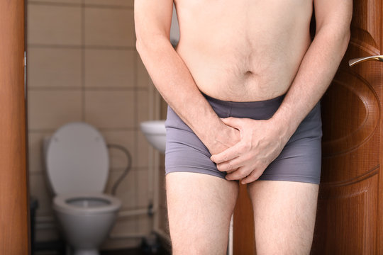 Mature man with urological problems suffering from pain near toilet