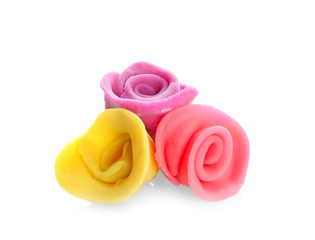 Colorful roses made from play dough on white background
