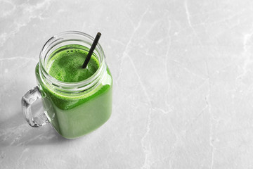 Mason jar with delicious detox juice on light background