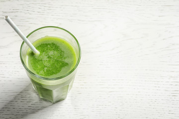 Glass with delicious detox juice on light background